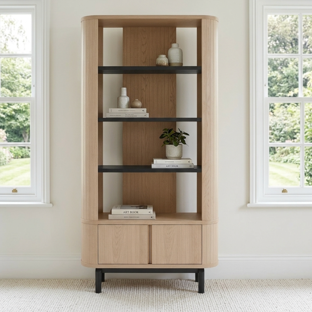 Wooden bookshelf with decorative items in a room with windows showing greenery