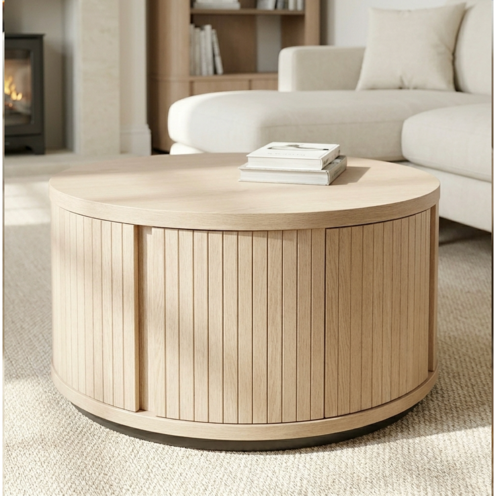 Round wooden coffee table in a living room setting with books on top
